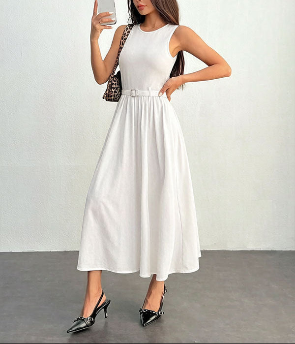 Woman in a white dress taking a selfie against a plain background